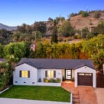 A single-story white house with a garage, surrounded by greenery, situated on Lucinda Ln in Santa Barbara's 93105 zip code area, with hills in the background.